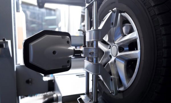 Modern technologies in use. Close up of car tyre fixed in alignment machine clap while being checked