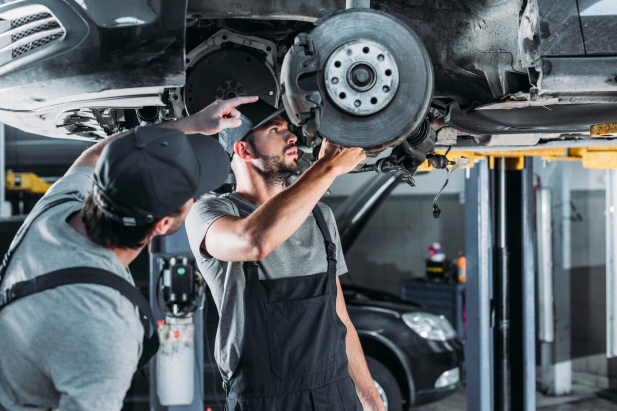 auto mechanics repairing car wheel